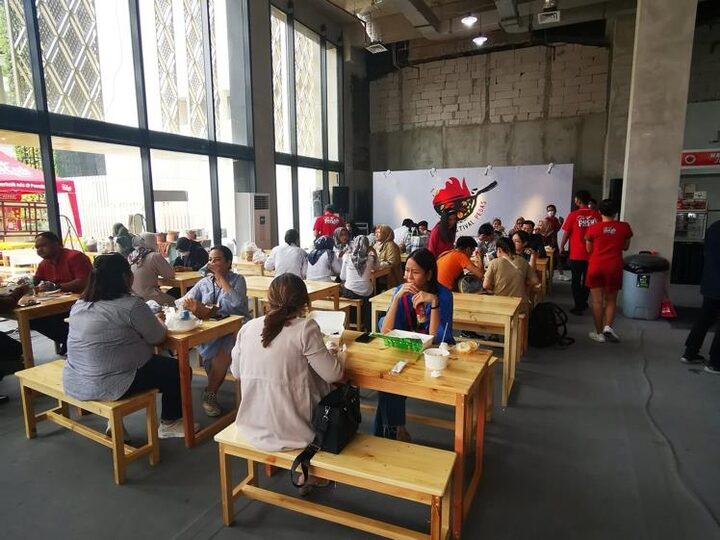 Visitors eating at communal tables inside the mall